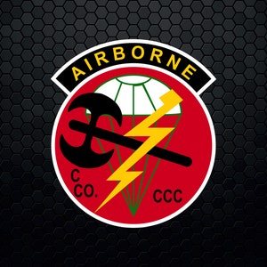May include: A red, white and green patch with the words "AIRBORNE" in a black circle around the outside. Inside the circle is a black axe with a yellow lightning bolt and a white parachute. The words "C CO." and "CCC" are written in black at the bottom of the patch.