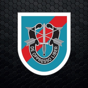 Puede incluir: Un parche militar azul y rojo con un borde blanco. El parche presenta un águila negra con flechas cruzadas y una daga. El texto "DE OPPRESSO LIBER" está escrito alrededor del águila.