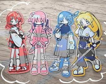 May include: Four colorful anime-style character stickers with different hairstyles and clothing. The characters are holding swords and have different expressions on their faces. The stickers are on a wooden surface.