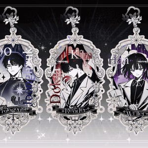 May include: Three decorative acrylic charms with anime-style illustrations. Each charm features a character portrait, text, and an ornate frame. The text includes "The Protagonist", "The Reader", and "The Writer".