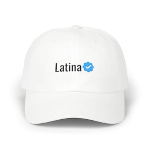 以下が含まれることがあります： 黒い文字で「Latina」と書かれ、その後に白いチェックマークが入った青い認証バッジアイコンが付いた白い野球帽。この帽子は、構造化されたクラウン、湾曲したつば、およびパネルの上部中央にあるボタンを備えています。