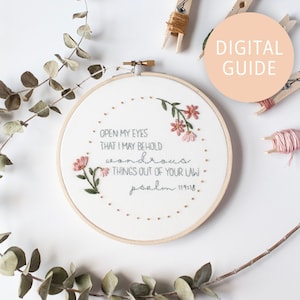 May include: Embroidered hoop art with a floral design and the text "OPEN MY EYES THAT I MAY BEHOLD wondrous THINGS OUT OF YOUR LAW psalm 119:18".