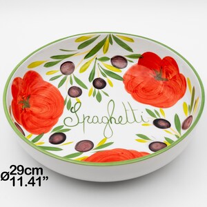 Op de afbeelding: Witte keramische spaghettikom met een groene rand, met handgeschilderde rode tomaten, zwarte olijven en groene bladeren. Het woord "Spaghetti" is in groene letters geschreven. De kom heeft een diameter van 29 cm.