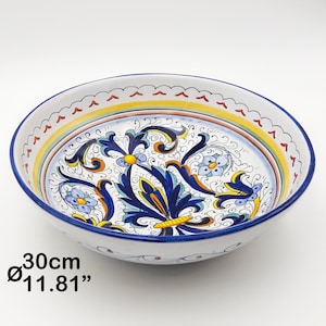 Może przedstawiać: Duża biała ceramiczna miska z niebieskim i żółtym wzorem kwiatowym. Miska ma średnicę 30 cm.