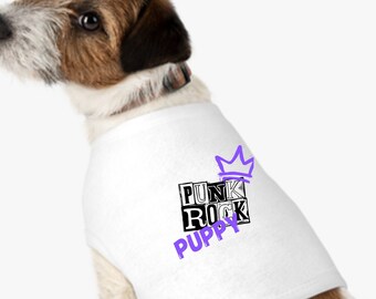 May include: A white dog wearing a white dog shirt with a purple crown and the words "Punk Rock Puppy" in black and white.