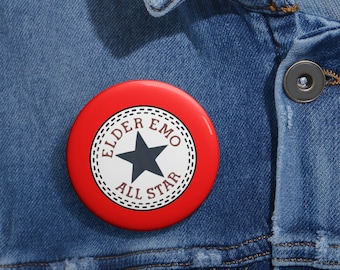 May include: Red button with a white circle and black star. The text "Elder Emo All Star" is written around the circle.