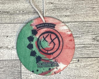 May include: A round, green and red tie-dye car air freshener with a black and white smiley face and the text "Where are you?" and "No seriously, turn your GPS on".