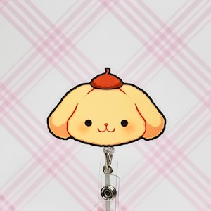 Pode incluir: Um cão de desenho animado amarelo com um boné vermelho, usando um porta-crachá de plástico transparente com um clipe de metal.