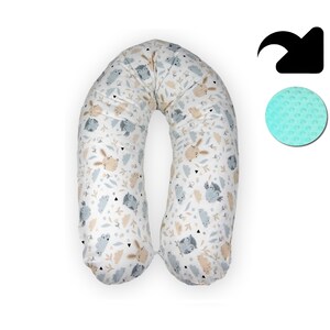 May include: A U-shaped pregnancy pillow with a white background and a pattern of brown rabbits, gray owls, and beige clouds. The pillow is made of soft, breathable fabric and is designed to provide support and comfort during pregnancy.