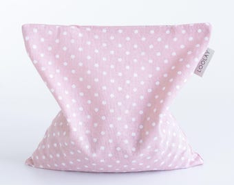 May include: A pink, polka-dot pillow with a V-shaped design. The pillow is made of fabric and features white polka dots. A small tag with the word "LOOLAY" is attached to the side.