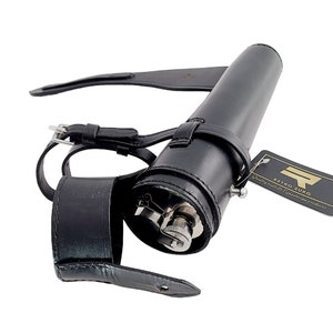 May include: Black leather flask with a silver cap and a black leather carrying strap. The strap has a buckle and a loop. The flask is labelled "Retro Surg Quality tools & equestrian products".