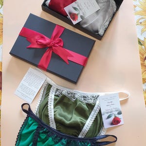 Peut inclure: Plusieurs culottes en soie, rouges, argentées, vertes et olive, sont présentées. Certaines sont dans des boîtes noires avec des rubans rouges. Les culottes ont des bordures en dentelle et des détails délicats. Sans mesures.