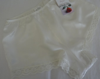 May include: White satin shorts with a lace trim. The shorts have a silky feel and are perfect for layering under dresses or skirts.