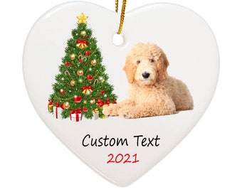 May include: Heart-shaped Christmas ornament with a golden retriever dog and a decorated Christmas tree. The ornament has a gold string for hanging and the text "Custom Text 2021".