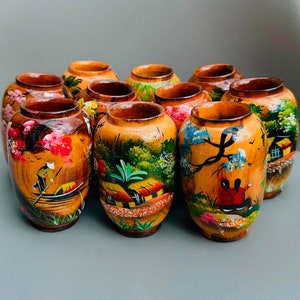 May include: A collection of ten small wooden vases with hand-painted designs. The vases are decorated with colourful floral and landscape scenes.