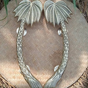 Puede incluir: Un par de tiradores de puerta de palmera dorada. Los tiradores están hechos de metal y tienen un diseño detallado. Son perfectos para agregar un toque tropical a cualquier hogar.