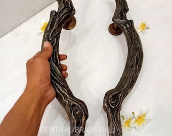 May include: A pair of rustic, brown, metal door handles shaped like tree branches. The handles have a textured surface and are designed to resemble natural wood.