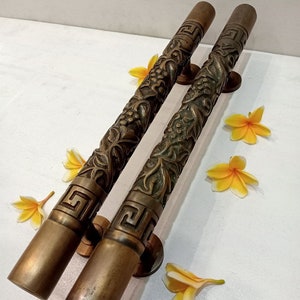 May include: A pair of ornate brass door handles with intricate floral designs and a Greek key pattern. The handles are made of solid brass and have a polished finish.