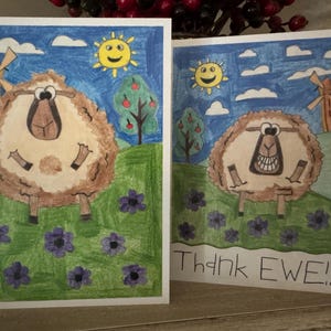 Puede incluir: Dos tarjetas de felicitaci&oacute;n con una oveja de dibujos animados en cada una. Las ovejas son marrones y blancas y tienen una cara sonriente. Las tarjetas tienen un fondo de cielo azul con nubes y un sol. El texto de la segunda tarjeta dice "Thank Ewe!!".