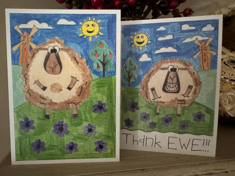 Puede incluir: Dos tarjetas de felicitaci&oacute;n con una oveja de dibujos animados en cada una. Las ovejas son marrones y blancas y tienen una cara sonriente. Las tarjetas tienen un fondo de cielo azul con nubes y un sol. El texto de la segunda tarjeta dice "Thank Ewe!!".