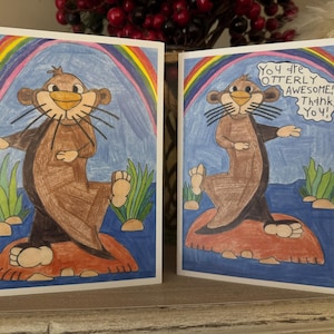 Puede incluir: Dos tarjetas de felicitaci&oacute;n con una nutria de dibujos animados en cada una. La nutria es marr&oacute;n y tiene un arco&iacute;ris detr&aacute;s. El texto de la tarjeta dice "&iexcl;Eres totalmente incre&iacute;ble! &iexcl;Gracias!"