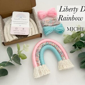 May include: A DIY rainbow kit with Liberty print fabric, pink and blue yarn, and white macrame cord. The kit includes instructions for making a rainbow wall hanging. The kit is called "Liberty DIY Rainbow Kit Michelle".
