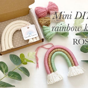 May include: A DIY mini rainbow kit with pink, green and gold yarn. The kit includes a pre-made white rainbow with tassels and a tag that says "Lula Love". The kit is labelled "Mini DIY rainbow kit ROSE".