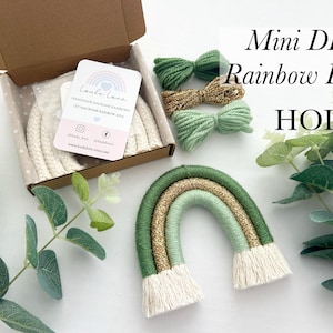 May include: A DIY mini rainbow kit with green and gold yarn, and white cord. The kit is packaged in a white box with a label that says "Little Lane Handmade Macrame Rainbow Kit".