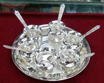 May include: A silver serving tray with six small silver bowls and spoons. The tray and bowls are polished to a high shine.