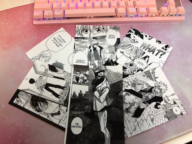 May include: A collection of black and white manga comic book pages featuring different characters and scenes. The pages are stacked on top of each other and include text such as "It's okay, I don't really get it either" and "WHAT?"