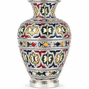 Peut inclure: Un vase de couleur argentée doté d'un col large et d'un corps arrondi, orné de motifs géométriques complexes aux couleurs émaillées vives, notamment le rouge, le vert, le bleu et le jaune. La surface métallique présente des textures détaillées.