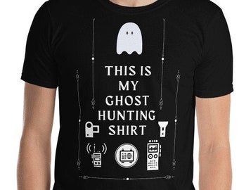 May include: Black t-shirt with a white ghost graphic and the text "THIS IS MY GHOST HUNTING SHIRT". The shirt also features illustrations of ghost hunting equipment. A short-sleeved crew neck tee.