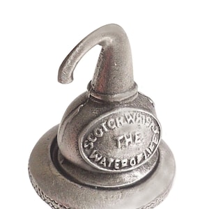 Peut inclure: Un bouchon de bouteille en argent avec une base en liège. Le bouchon est doté d'un bec verseur et d'un motif circulaire qui indique "Scotch Whisky The Water of Life".