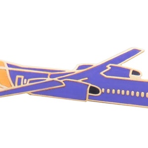 May include: A blue and gold airplane pin. The pin depicts a passenger airplane with gold trim outlining the wings, fuselage, and tail. The airplane has a blue body with orange and white accents.