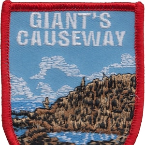 May include: An embroidered patch featuring the text "Giant's Causeway" and a depiction of the Giant's Causeway in Northern Ireland. The patch is red, white and blue.