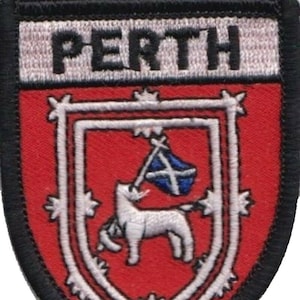 Op de afbeelding: Een rood en wit geborduurde patch met het woord "PERTH" in zwarte letters. De patch toont een wit eenhoorn dat een blauw-witte vlag vasthoudt.