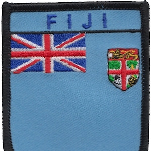 May include: A blue and white embroidered patch with the word "FIJI" at the top. The patch features a Union Jack flag on the left and a coat of arms on the right.