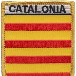 Könnte beinhalten: Ein gestickter Aufnäher in Gelb und Rot mit dem Wort "CATALONIA" in schwarzen Buchstaben auf weißem Hintergrund.