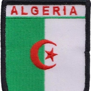 May include: Embroidered patch featuring the word "ALGERIA" in red letters above a green and white design. The design includes a red crescent moon and star, with a black border.