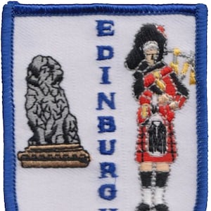 May include: Embroidered patch with a white background and blue border. The patch features a grey stone lion on the left and a man in a red kilt playing a bagpipe on the right. The word "EDINBURGH" is vertically centered in blue.