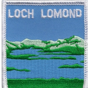 Pode incluir: Etiqueta bordada com uma imagem azul e verde de Loch Lomond, Escócia. A etiqueta tem costuras brancas ao redor das bordas e as palavras "Loch Lomond" em texto branco na parte superior.
