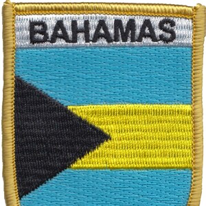 May include: An embroidered patch featuring the flag of the Bahamas. The patch is gold with a blue, yellow, and black flag in the center. The words "Bahamas" are embroidered in black on a white background at the top of the patch.
