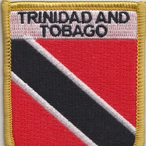 May include: A red, white, and black embroidered patch with the text "TRINIDAD AND TOBAGO" in black lettering. The patch is surrounded by a gold border.