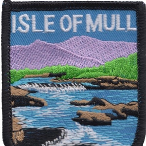 May include: Embroidered patch with the text "ISLE OF MULL" in white lettering on a blue background. The patch depicts a scenic landscape with purple mountains, green trees, and a blue river with white rapids.