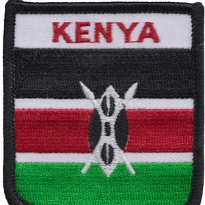 May include: Embroidered patch featuring the flag of Kenya. The flag is a horizontal triband of black, red, and green with a white stripe in the center. A traditional Maasai shield and spears are centered on the white stripe. The word "KENYA" is embroidered in red on a white background at the top of the patch.