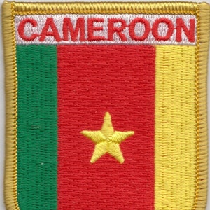 May include: Embroidered patch featuring the flag of Cameroon. The patch is gold with a red, green, and yellow flag with a yellow star in the center. The words "CAMEROON" are embroidered in white on a white background at the top of the patch.