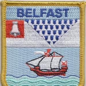 May include: Embroidered patch with the word "BELFAST" in blue lettering. The patch features a white bell on a red background, a blue and white checkered pattern, a white ship with red accents sailing on blue water, and a green wavy line representing the sea.