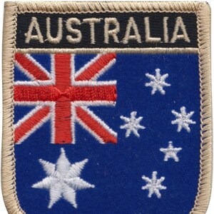 May include: A blue and white embroidered patch with the word "AUSTRALIA" in white text on a black background. The patch features the Australian flag with the Union Jack in the upper left corner and five white stars on a blue background.