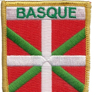 Peut inclure: Un écusson brodé rouge, blanc et vert avec le mot "BASQUE" en lettres vertes. L'écusson a une bordure dorée.
