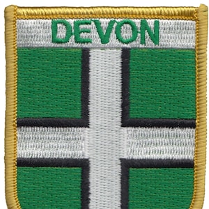 May include: A green and white embroidered patch with the word "DEVON" in green letters on a white background. The patch has a gold border.